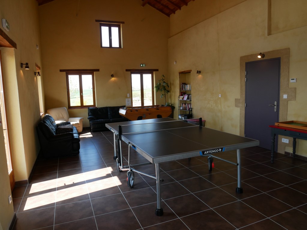 Une grande salle de jeux avec ping-pong et baby-foot